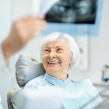 Tummarello & Pandak <br>Family Dentistry elderly female smiling on a dentist chair
